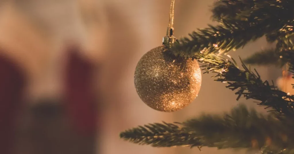 Golden Christmas ordainment, hanging from a Christmas tree