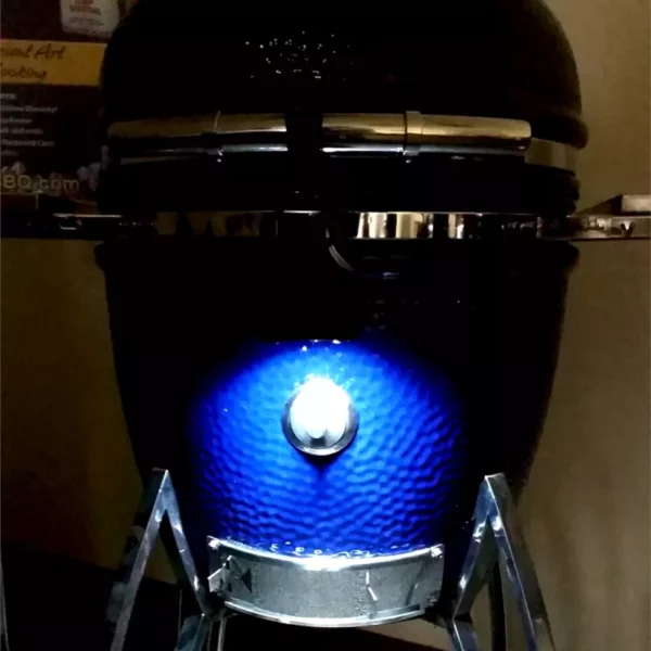 A GL-320 Maverick grill light is shown mounted to a Saffire so that the light shines down on the smoking chip feeder port when the grill is closed