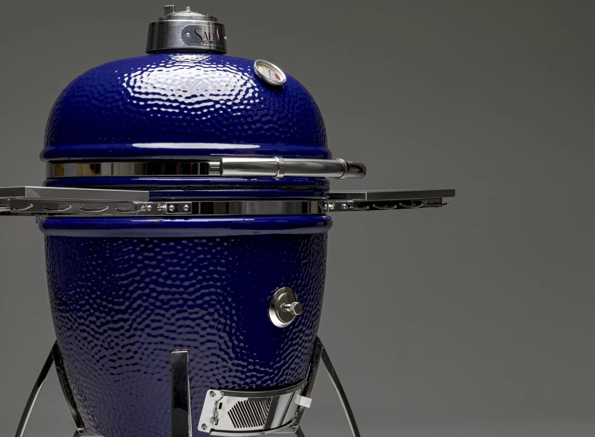 A glamor shot of a blue Saffire charcoal grill