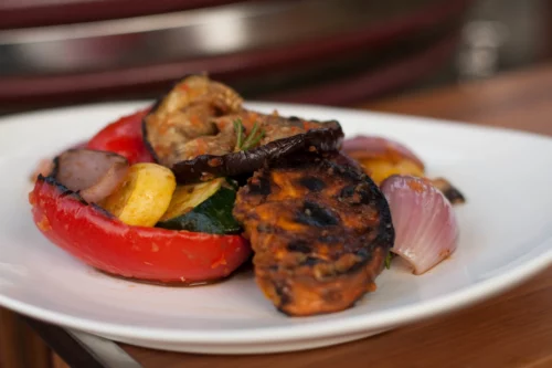 Grilled Squash, Sweet Potato, Bell Peppers, Onion, and Other Veggetables Sitting on a Plate and Ready to be Served