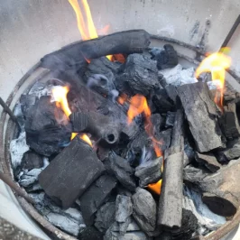 Lump charcoal burns inside of a Crucible Firebox.