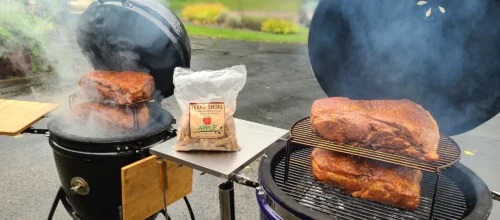 Four pork shoulders are shown being smoked on two Saffire grills.