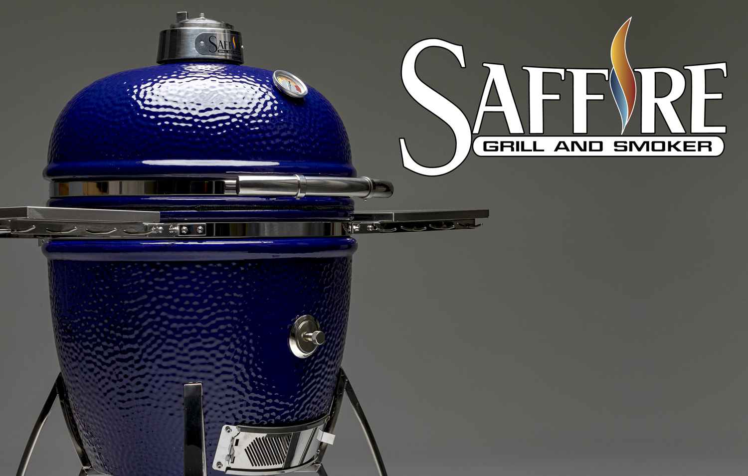 The Saffire ceramic kamado grill stands at an angle, with the beautiful blue enameled glaze glistening in the light.